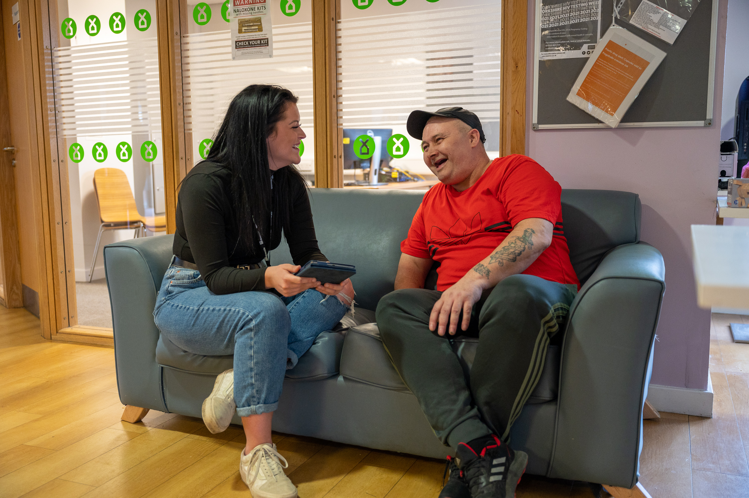 Two people sat on a couch laughing together